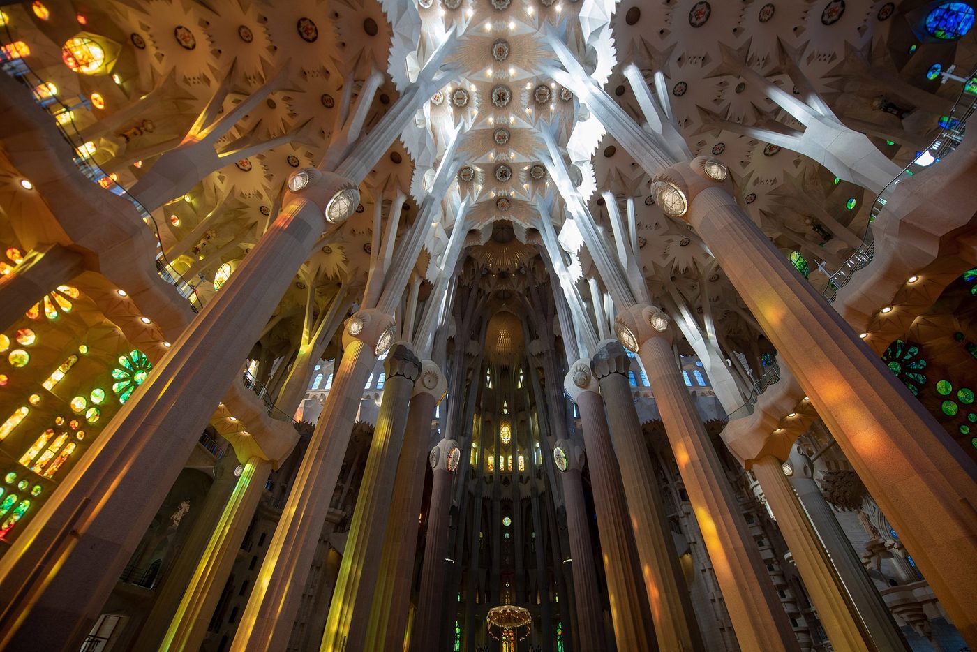 Nave vaults and coloured windows seen from below.