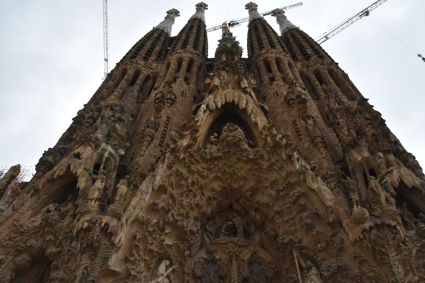 Nativity façade bell towers beneath a cloudy sky.