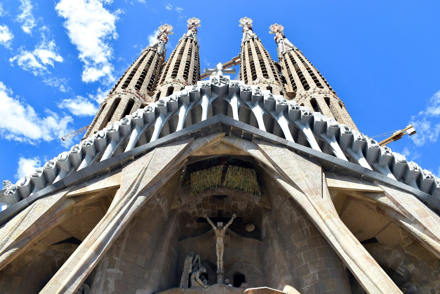 Slanting columns on the Passion façade beneath blue sky.