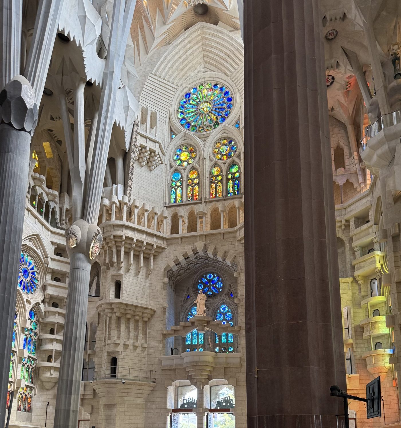 A column before coloured windows and a rose window.